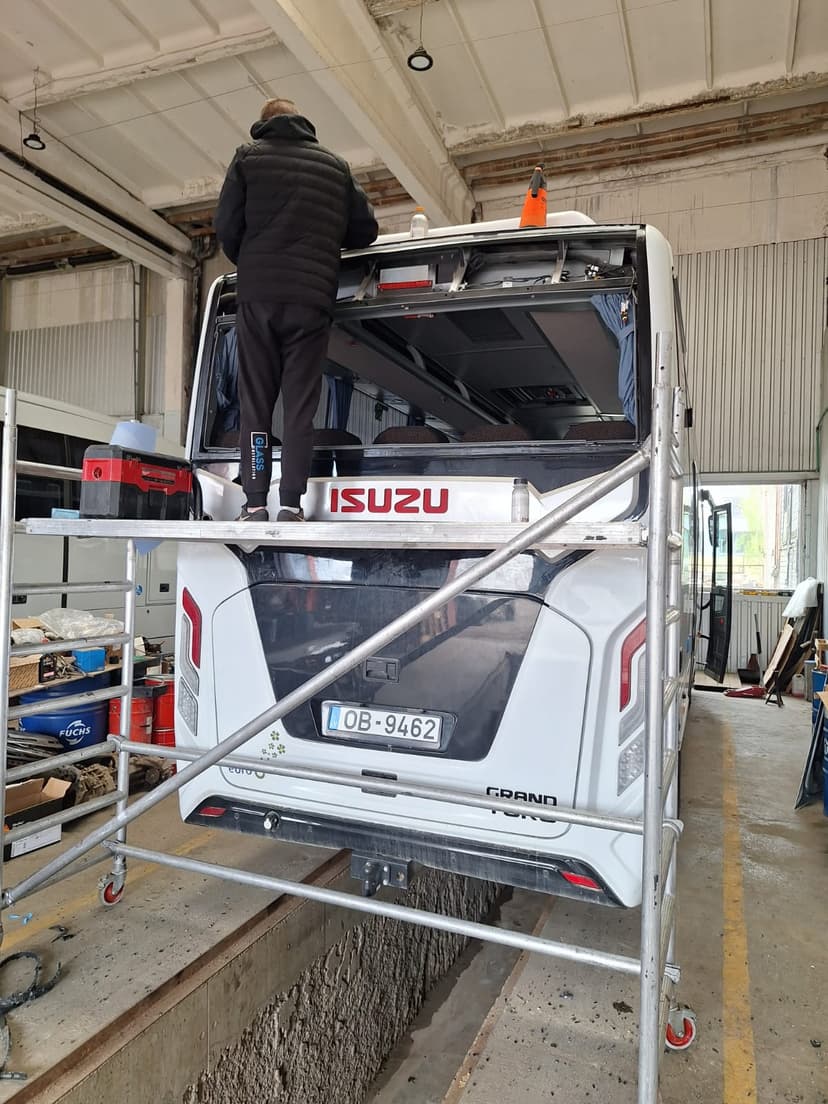Autobusa aizmugurējā stikla paketes nomaiņa angāra telpās